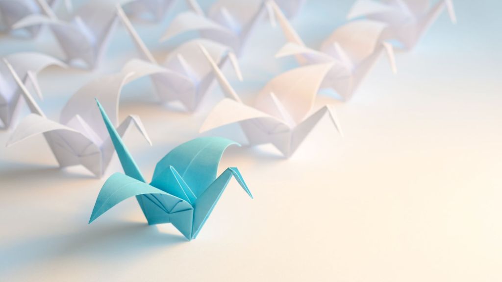 Image of an origami paper crane in teal and white. This image representing the importance to stand out as far as brand recognition goes.